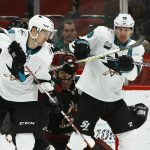 San Jose Sharks center Tomas Hertl, left, and center Logan Couture (39) try to redirect the puck in front of Arizona Coyotes goaltender Adin Hill, middle, during the second period of an NHL hockey game, Saturday, Dec. 8, 2018, in Phoenix. (AP Photo/Ross D. Franklin)