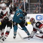 San Jose Sharks' Joe Pavelski (8) battles for the puck against Arizona Coyotes' Darcy Kuemper (35), Alex Goligoski (33) and Oliver Ekman-Larsson (23) in the second period of an NHL hockey game in San Jose, Calif., Sunday, Dec. 23, 2018. (AP Photo/Josie Lepe)