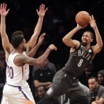 Brooklyn Nets' Spencer Dinwiddie (8) passes away from Phoenix Suns' Troy Daniels (30) during the first half of an NBA basketball game Sunday, Dec. 23, 2018, in New York. (AP Photo/Frank Franklin II)