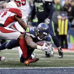 Seattle Seahawks' Chris Carson (32) dives into the end zone for a touchdown past Arizona Cardinals' Antoine Bethea during the first half of an NFL football game, Sunday, Dec. 30, 2018, in Seattle. (AP Photo/Ted S. Warren)