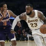 Los Angeles Lakers' LeBron James (23) dribbles next to Phoenix Suns' Trevor Ariza (3) during the second half of an NBA basketball game Sunday, Dec. 2, 2018, in Los Angeles. (AP Photo/Marcio Jose Sanchez)