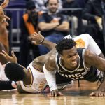 Sacramento Kings' Buddy Hield (24) falls hard as he battles for a ball with Phoenix Suns' Troy Daniels (30) during the first half of an NBA basketball game, Tuesday, Dec. 4, 2018, in Phoenix. (AP Photo/Darryl Webb)