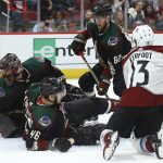Colorado Avalanche center Alexander Kerfoot (13) gets the puck past Arizona Coyotes defenseman Ilya Lyubushkin (46), defenseman Jordan Oesterle (82) and goaltender Adin Hill (31) for a goal during the first period of an NHL hockey game Saturday, Dec. 22, 2018, in Glendale, Ariz. (AP Photo/Ross D. Franklin)
