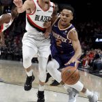 Phoenix Suns guard Elie Okobo, right drives to the basket on Portland Trail Blazers guard Seth Curry, left, during the first half of an NBA basketball in Portland, Ore., Thursday, Dec. 6, 2018. (AP Photo/Steve Dykes)