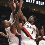 Portland Trail Blazers guard Damian Lillard, left, and forward Al-Farouq Aminu, right, go up for a rebound during the first half of an NBA basketball game against the Phoenix Suns in Portland, Ore., Thursday, Dec. 6, 2018. (AP Photo/Steve Dykes)