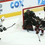 San Jose Sharks center Lukas Radil (52) gets the puck past Arizona Coyotes goaltender Adin Hill (31), defenseman Jordan Oesterle (82) and center Brad Richardson (15) for a goal during the third period of an NHL hockey game, Saturday, Dec. 8, 2018, in Phoenix. The Sharks defeated the Coyotes 5-3. (AP Photo/Ross D. Franklin)