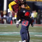 Arizona State quarterback Manny Wilkins jumps over Fresno State defensive back Juju Hughes (23) during the first half of the Las Vegas Bowl NCAA college football game, Saturday, Dec. 15, 2018, in Las Vegas. (AP Photo/John Locher)