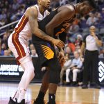 Miami Heat forward Rodney McGruder (17) holds on to Phoenix Suns center Deandre Ayton after fouling him during the second half during an NBA basketball game Friday, Dec. 7, 2018, in Phoenix. The Heat defeated the Suns 115-98. (AP Photo/Rick Scuteri)