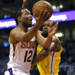 Phoenix Suns forward T.J. Warren (12) drives by Golden State Warriors forward Kevin Durant during the second half during an NBA basketball game Monday, Dec. 31, 2018, in Phoenix. Golden State defeated the Suns 132-109. (AP Photo/Rick Scuteri)