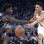 Phoenix Suns guard Devin Booker (1), right, passes the ball in front of Orlando Magic forward Jonathan Isaac (1) during the first half of an NBA basketball game Wednesday, Dec. 26, 2018, in Orlando, Fla. (AP Photo/Phelan M. Ebenhack)