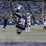 Seattle Seahawks' Tyler Lockett (16) flips his way into the end zone on a 29-yard touchdown reception against the Arizona Cardinals during the first half of an NFL football game, Sunday, Dec. 30, 2018, in Seattle. (AP Photo/John Froschauer)