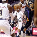 Denver Nuggets guard Monte Morris (11) dishes off to forward Paul Millsap (4) as Phoenix Suns forward Josh Jackson (20) defends during the first half of an NBA basketball game, Saturday, Dec. 29, 2018, in Phoenix. (AP Photo/Matt York)