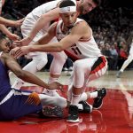 Phoenix Suns forward Mikal Bridges, left, and Portland Trail Blazers guard Seth Curry, right, battle for the ball during the first half of an NBA basketball game in Portland, Ore., Thursday, Dec. 6, 2018. (AP Photo/Steve Dykes)