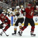 Arizona Coyotes right wing Richard Panik (14) skates around Vegas Golden Knights right wing Reilly Smith (19) and Coyotes defenseman Ilya Lyubushkin, right, to get to the puck during the first period of an NHL hockey game Sunday, Dec. 30, 2018, in Glendale, Ariz. (AP Photo/Ross D. Franklin)