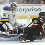 Arizona Coyotes right wing Josh Archibald, right, crashes into St. Louis Blues goaltender Chad Johnson (31) as Johnson makes a save on a shot during the second period of an NHL hockey game, Saturday, Dec. 1, 2018, in Glendale, Ariz. (AP Photo/Ross D. Franklin)