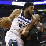 Minnesota Timberwolves center Karl-Anthony Towns (32) drives to the basket as Phoenix Suns forward Richaun Holmes defends during the first half of an NBA basketball game, Saturday, Dec. 15, 2018, in Phoenix. (AP Photo/Ralph Freso)