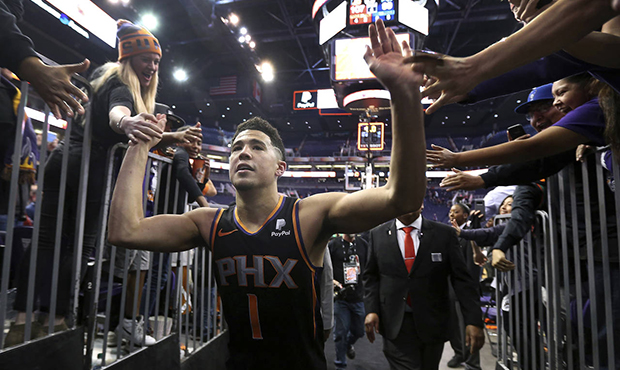 Phoenix Suns guard Devin Booker (1) high-fives fans as he leaves the court following a 107-99 victo...