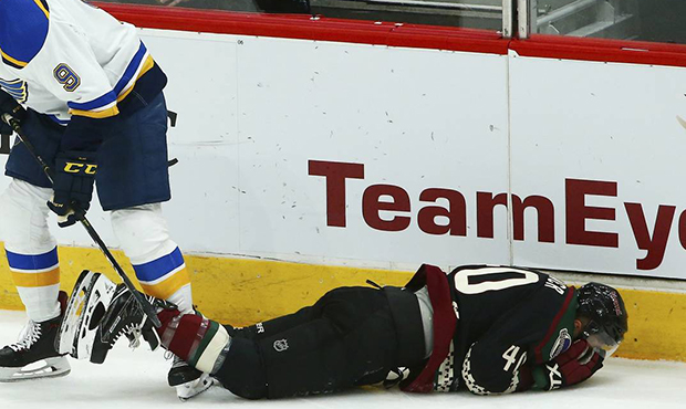Arizona Coyotes right wing Michael Grabner, right, falls to the ice due to injury as St. Louis Blue...