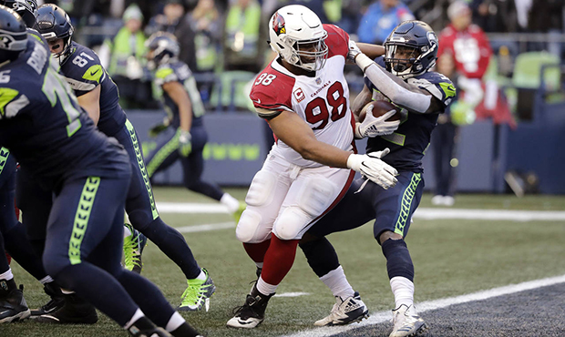 Seattle Seahawks' Chris Carson, right, spins away from Arizona Cardinals' Corey Peters to move out ...