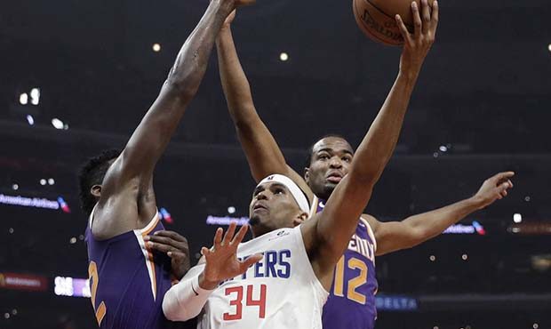 Los Angeles Clippers' Tobias Harris (34) shoots between Phoenix Suns' Deandre Ayton, left, and T.J....