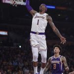 Los Angeles Lakers guard Kentavious Caldwell-Pope, left, goes up for a dunk as Phoenix Suns forward Kelly Oubre Jr. watches during the first half of an NBA basketball game Sunday, Jan. 27, 2019, in Los Angeles. (AP Photo/Mark J. Terrill)