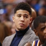 Phoenix Suns guard Devin Booker looks on from the bench during the first half of an NBA basketball game against the Dallas Mavericks, Wednesday, Jan. 9, 2019, in Dallas. Booker did not play due to an earlier injury. (AP Photo/Jim Cowsert)