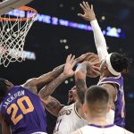 Los Angeles Lakers forward Michael Beasley, second from left, shoots as Phoenix Suns forward Josh Jackson, left, and forward Richaun Holmes, right, defend during the first half of an NBA basketball game, Sunday, Jan. 27, 2019, in Los Angeles. (AP Photo/Mark J. Terrill)