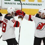 New Jersey Devils defenseman Will Butcher, right, celebrates the team's win over the Arizona Coyotes with right wing Drew Stafford (18) and left wing Brett Seney after the shootout of an NHL hockey game Friday, Jan. 4, 2019, in Glendale, Ariz. The Devils won 3-2. (AP Photo/Ross D. Franklin)