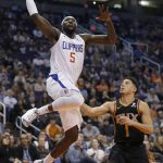 Los Angeles Clippers forward Montrezl Harrell (5) drives past Phoenix Suns guard Devin Booker in the first half during an NBA basketball game, Friday, Jan. 4, 2019, in Phoenix. (AP Photo/Rick Scuteri)
