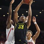 Oregon forward Francis Okoro (33) drives between Arizona guard Dylan Smith, left, and Chase Jeter (4) in the first half of an NCAA college basketball game, Thursday, Jan. 17, 2019, in Tucson, Ariz. (AP Photo/Rick Scuteri)