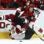 Arizona Coyotes right wing Richard Panik (14) flips over New Jersey Devils defenseman Ben Lovejoy (12) as Panik passes the puck during the first period of an NHL hockey game Friday, Jan. 4, 2019, in Glendale, Ariz. (AP Photo/Ross D. Franklin)