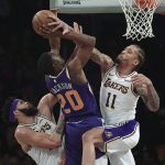 Phoenix Suns forward Josh Jackson, center, shoots as Los Angeles Lakers center JaVale McGee, left, and forward Michael Beasley defend during the first half of an NBA basketball game Sunday, Jan. 27, 2019, in Los Angeles. (AP Photo/Mark J. Terrill)