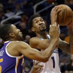 Charlotte Hornets guard Malik Monk, right, shoots in front of Phoenix Suns forward Mikal Bridges, left, in the first half during an NBA basketball game, Sunday, Jan. 6, 2019, in Phoenix. (AP Photo/Rick Scuteri)