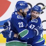 Vancouver Canucks' Alexander Edler (23), of Sweden, and Sven Baertschi (47), of Switzerland, celebrate Baertschi's goal against the Arizona Coyotes during the second period of an NHL hockey game Thursday, Jan. 10, 2019, in Vancouver, British Columbia. (Darryl Dyck /The Canadian Press via AP)