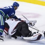 Vancouver Canucks' Nikolay Goldobin, left, of Russia, loses control of the puck while attempting a shot on Arizona Coyotes goalie Darcy Kuemper during the second period of an NHL hockey game Thursday, Jan. 10, 2019, in Vancouver, British Columbia. (Darryl Dyck/The Canadian Press via AP)
