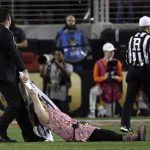 A fan is removed after running on the field during the first half the NCAA college football playoff championship game between Alabama and Clemson, Monday, Jan. 7, 2019, in Santa Clara, Calif. (AP Photo/David J. Phillip)