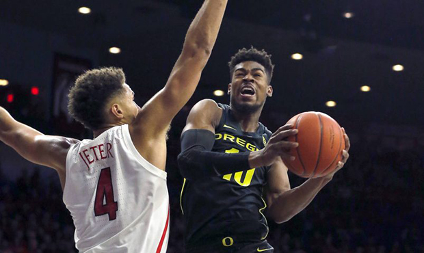 Oregon guard Victor Bailey Jr. (10) drives on Arizona center Chase Jeter in the first half of an NC...