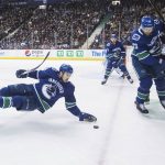 Vancouver Canucks' Tyler Motte, left, falls as Alexander Edler (23), of Sweden, checks Arizona Coyotes' Christian Fischer (36) during the first period of an NHL hockey game Thursday, Jan. 10, 2019, in Vancouver, British Columbia. (Darryl Dyck /The Canadian Press via AP)