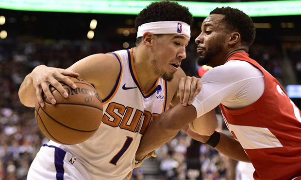 Phoenix Suns guard Devin Booker (1) controls the ball as Toronto Raptors forward Norman Powell (24)...