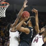 Colorado forward D'Shawn Schwartz (5) shoots the ball as Arizona State's De'Quon Lake, left, and Kimani Lawrence (14) defend during the first half of an NCAA college basketball game, Saturday, Jan. 5, 2019, in Tempe, Ariz. (AP Photo/Ralph Freso)