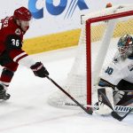 Arizona Coyotes right wing Christian Fischer (36) sends his shot off the skate of San Jose Sharks defenseman Erik Karlsson, right, before the puck slips past Sharks goaltender Aaron Dell (30) for a goal during the second period of an NHL hockey game Wednesday, Jan. 16, 2019, in Glendale, Ariz. (AP Photo/Ross D. Franklin)