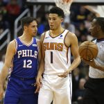 Philadelphia 76ers guard T.J. McConnell (12) and Phoenix Suns guard Devin Booker (1) talk in the first half during an NBA basketball game, Wednesday, Jan. 2, 2019, in Phoenix. (AP Photo/Rick Scuteri)