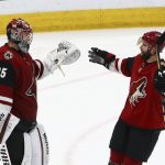 Arizona Coyotes goaltender Darcy Kuemper (35) celebrates a win against the San Jose Sharks with defenseman Alex Goligoski (33), at the end of an NHL hockey game Wednesday, Jan. 16, 2019, in Glendale, Ariz. The Coyotes defeated the Sharks 6-3. (AP Photo/Ross D. Franklin)
