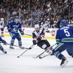 Arizona Coyotes' Conor Garland (83) skates with the puck past Vancouver Canucks' Nikolay Goldobin, left, of Russia, while Bo Horvat, second from left, and Derrick Pouliot (5) watch during the first period of an NHL hockey game Thursday, Jan. 10, 2019, in Vancouver, British Columbia. (Darryl Dyck /The Canadian Press via AP)