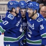 Vancouver Canucks' Ben Hutton, Adam Gaudette and Brandon Sutter, from let, celebrate Gaudette's goal against the Arizona Coyotes during the second period of an NHL hockey game Thursday, Jan. 10, 2019, in Vancouver, British Columbia. (Darryl Dyck/The Canadian Press via AP)
