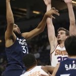 Minnesota Timberwolves' Karl-Anthony Towns shoots the ball over Phoenix Suns' Dragan Bender in the first half of an NBA basketball game Sunday, Jan. 20, 2019, in Minneapolis. (AP Photo/Stacy Bengs)