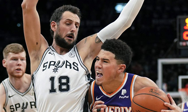 Phoenix Suns' Devin Booker (1) drives against San Antonio Spurs' Marco Belinelli during the first h...