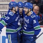 Vancouver Canucks' Ben Hutton, Adam Gaudette and Brandon Sutter, from left, celebrate Gaudette's goal against the Arizona Coyotes during the second period of an NHL hockey game Thursday, Jan. 10, 2019, in Vancouver, British Columbia. (Darryl Dyck/The Canadian Press via AP)