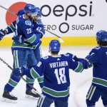 Vancouver Canucks' Alexander Edler (23), of Sweden; Sven Baertschi (47), of Switzerland; Jake Virtanen (18); and Chris Tanev (8) celebrate Baertschi's goal against the Arizona Coyotes during the second period of an NHL hockey game Thursday, Jan. 10, 2019, in Vancouver, British Columbia. (Darryl Dyck/The Canadian Press via AP)