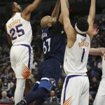 Minnesota Timberwolves' Taj Gibson tries to go up to the basket against Phoenix Suns' Mikal Bridges and Phoenix Suns' Devin Booker in the first half of an NBA basketball game Sunday, Jan. 20, 2019, in Minneapolis. (AP Photo/Stacy Bengs)